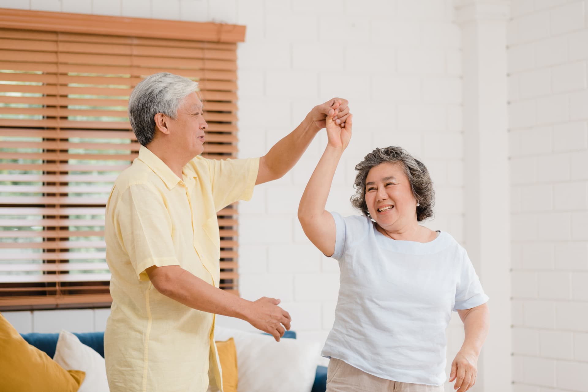 Older couple dancing at home, illustrating whole-body wellbeing